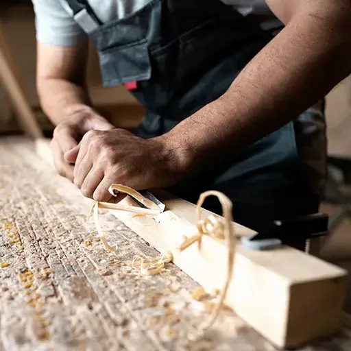 Interior carpentry work — handyman planing wood for trim and custom woodwork installation